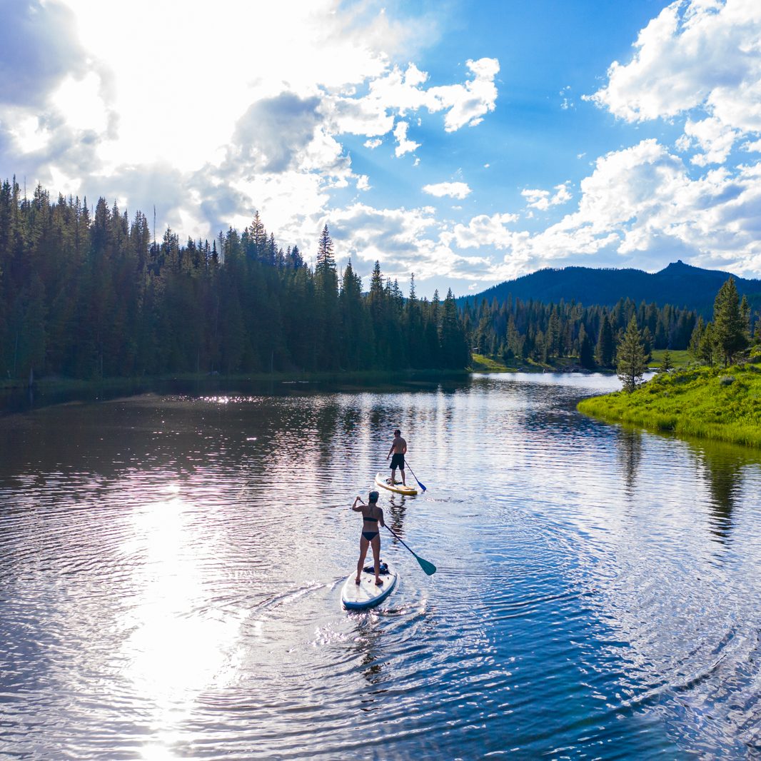 Couple paddle boarding down the Yampa River in Steamboat Springs, Colorado