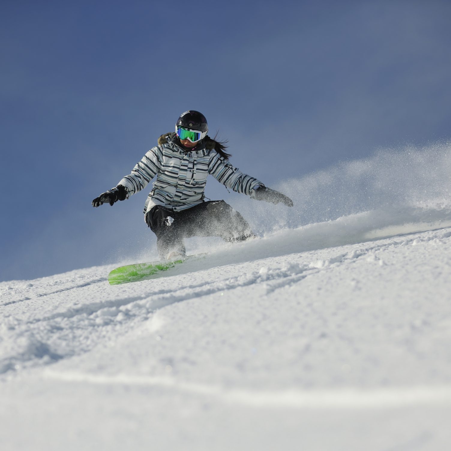 Woman Snowboarding down ski slope